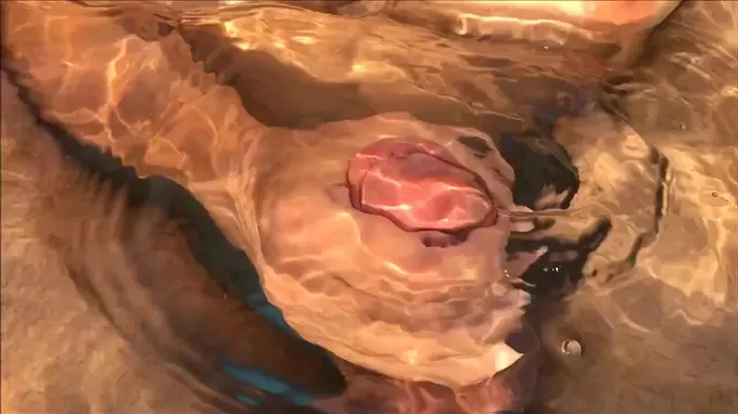 Horny naked babe giving him a hand job in the pool and gets cum covered