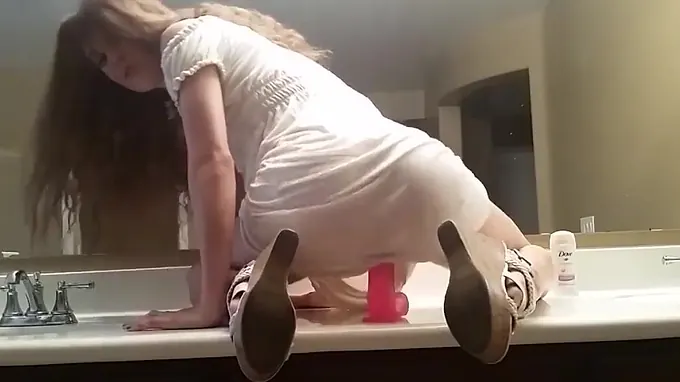 Teen babe gets on bathroom table to ride her long huge dildo