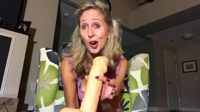Perky blonde is holding a huge dildo ready to fuck pussy hole