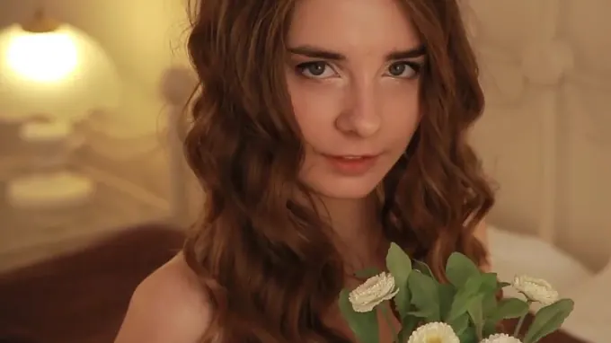 Cute curly teen is on her bed posing seductively showing her tits